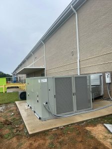 Commercial HVAC unit on a pad beside a building