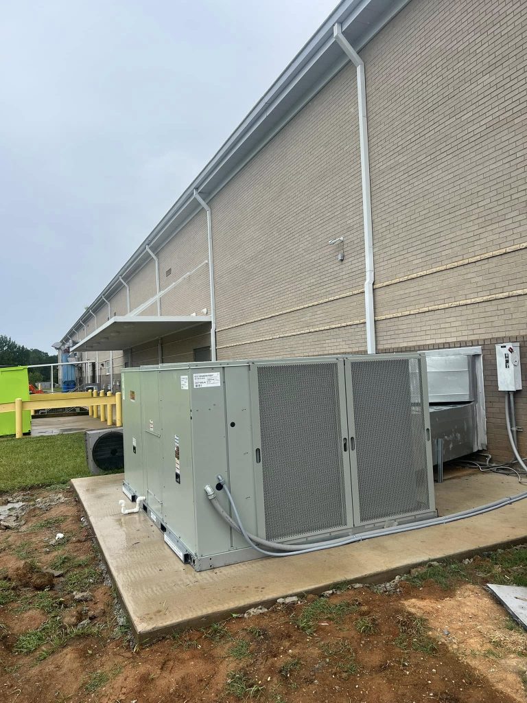 Commercial HVAC unit on a pad beside a building
