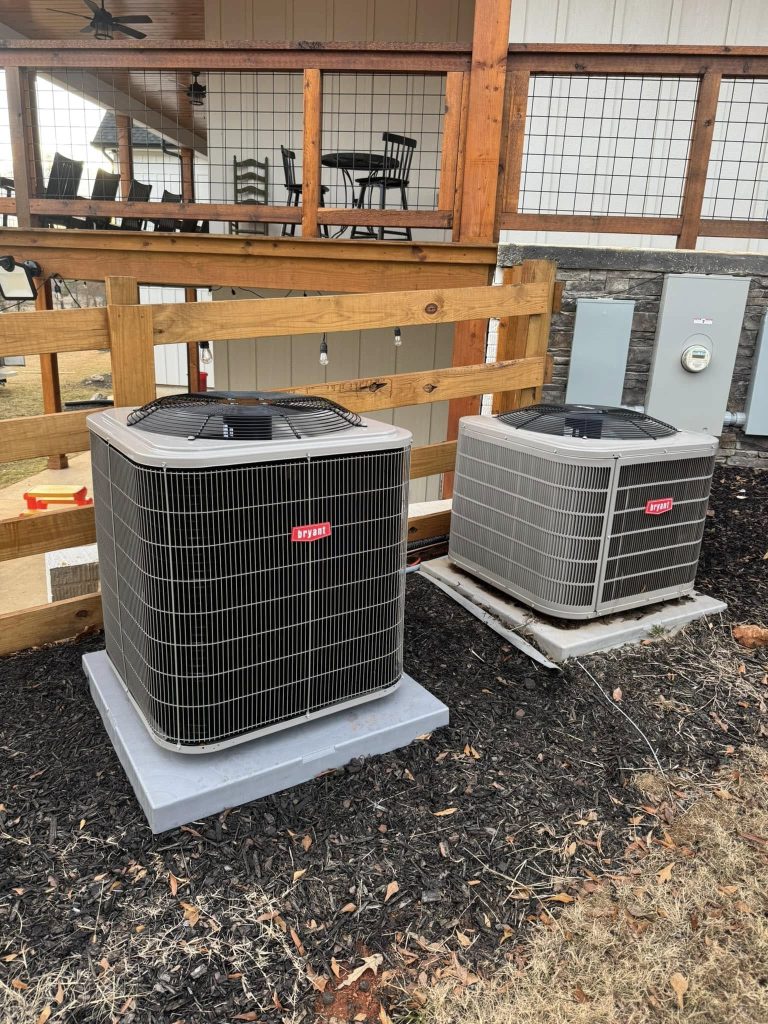Two new outdoor condensers on pads beside a patio