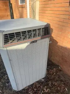 Trane condenser beside a brick wall